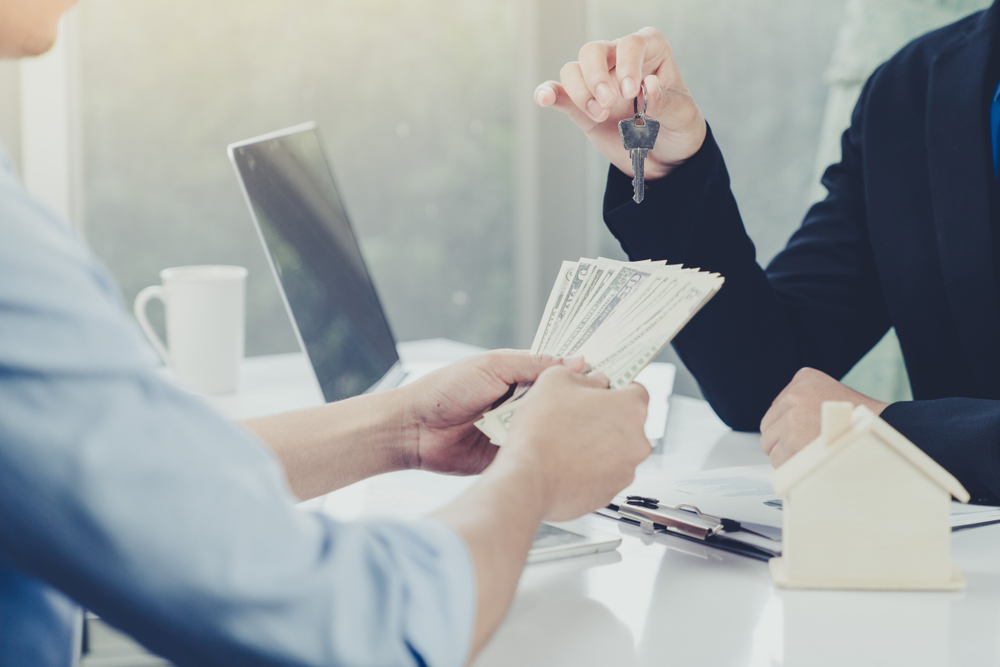 man handing money to lender who is passing over keys